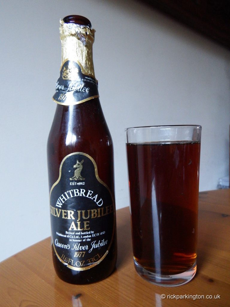A bottle of beer and a glass, the bottle label says Silver Jubilee Ale 1977